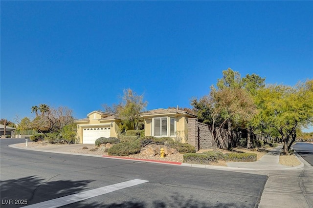 10302 Cara Mia Ct, Las Vegas, NV 89135 - view of front facade with an attached garage, stucco siding, and driveway