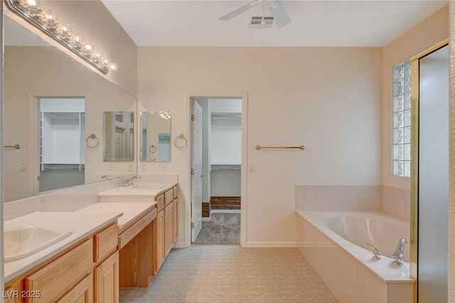 10302 Cara Mia Ct, Las Vegas, NV 89135 - full bathroom featuring a bath, double vanity, ceiling fan, tile patterned flooring, and baseboards