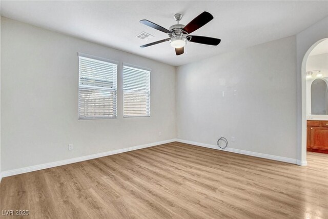 248 Windmill Croft Dr, Las Vegas, NV 89148 - empty room with light wood finished floors, arched walkways, baseboards, and a ceiling fan