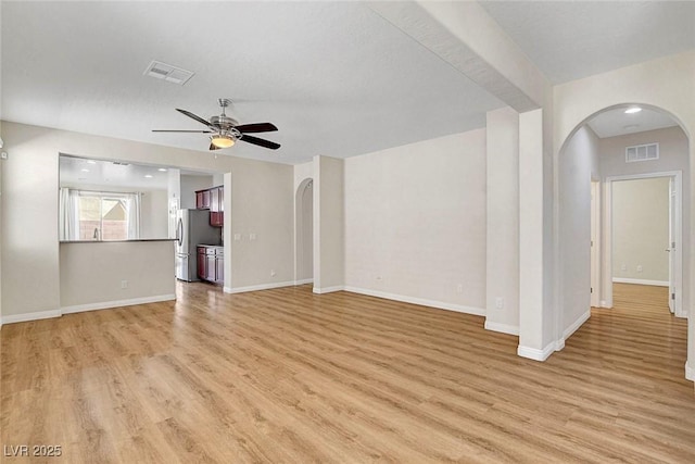 248 Windmill Croft Dr, Las Vegas, NV 89148 - unfurnished living room featuring arched walkways, light wood-style floors, a ceiling fan, and baseboards