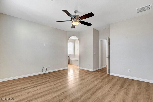 248 Windmill Croft Dr, Las Vegas, NV 89148 - empty room featuring arched walkways, light wood-style floors, ceiling fan, and baseboards