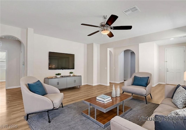 248 Windmill Croft Dr, Las Vegas, NV 89148 - living area with arched walkways, light wood-style flooring, and ceiling fan