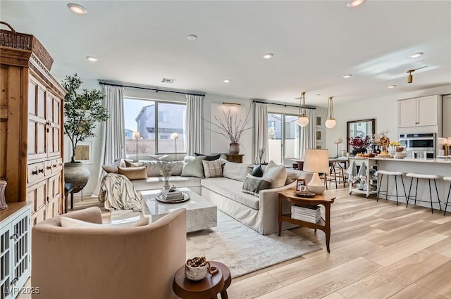 living room with light wood finished floors and recessed lighting