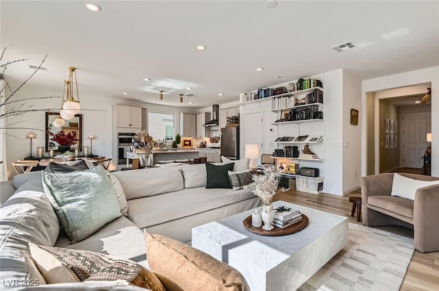 living area with light wood finished floors and recessed lighting