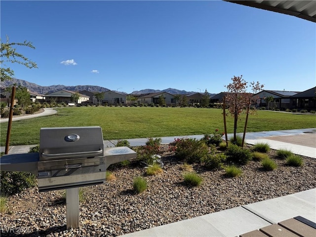 view of property's community with a residential view, a lawn, and a mountain view