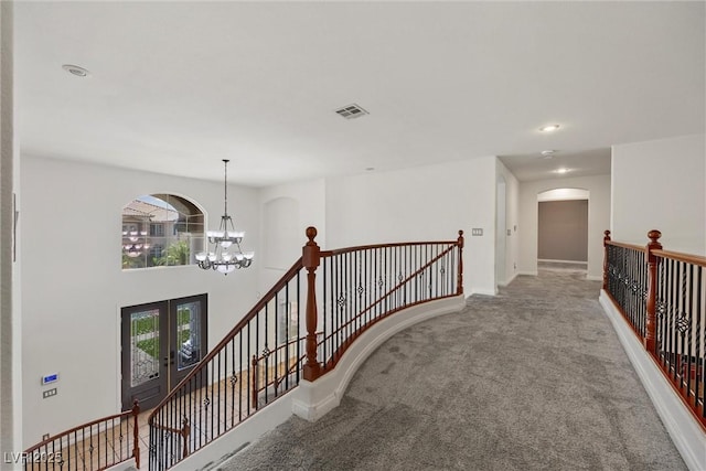 hallway with an upstairs landing, french doors, carpet floors, a chandelier, and recessed lighting