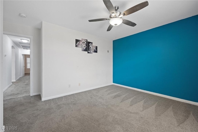 carpeted spare room with a ceiling fan, a smoke detector, and baseboards