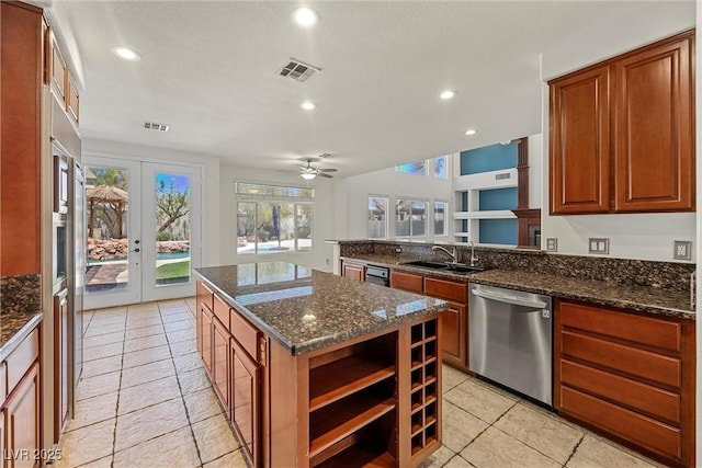 kitchen with dishwasher, a sink, open shelves, a center island, and dark stone counters