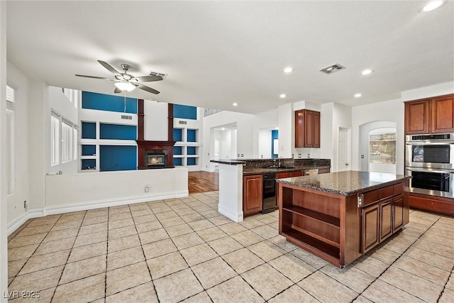 kitchen with stainless steel double oven, open shelves, a sink, a ceiling fan, and light tile patterned floors