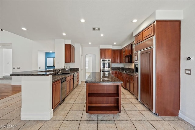 kitchen with open shelves, stainless steel appliances, a sink, light tile patterned floors, and a peninsula