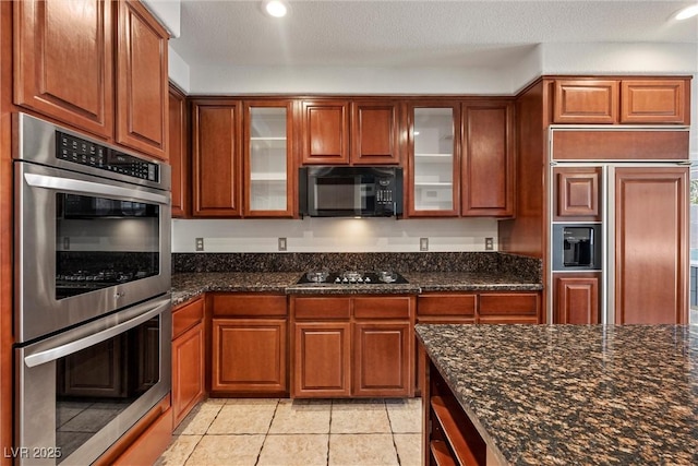 kitchen featuring black appliances, glass insert cabinets, brown cabinets, and recessed lighting