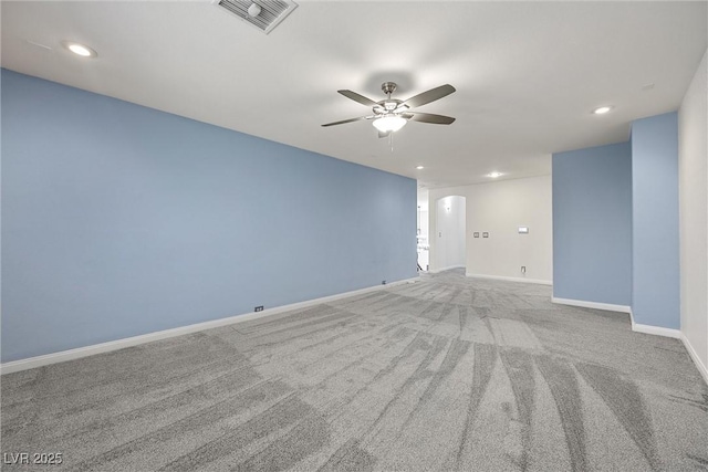 carpeted empty room with ceiling fan, recessed lighting, baseboards, and arched walkways