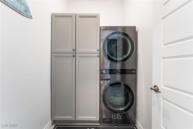 778 Dainty Daffodil St, Henderson, NV 89011 - laundry room featuring stacked washer / drying machine, cabinet space, and baseboards