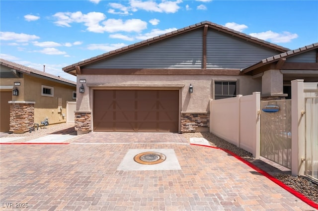 778 Dainty Daffodil St, Henderson, NV 89011 - view of front of house featuring stone siding, an attached garage, decorative driveway, and stucco siding