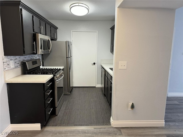 7885 W Flamingo Rd Unit 2019, Las Vegas, NV 89147 - kitchen with appliances with stainless steel finishes, dark cabinets, light countertops, and baseboards