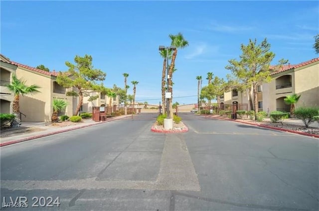 7885 W Flamingo Rd Unit 2019, Las Vegas, NV 89147 - view of asphalt road featuring a residential view, sidewalks, curbs, and a gate