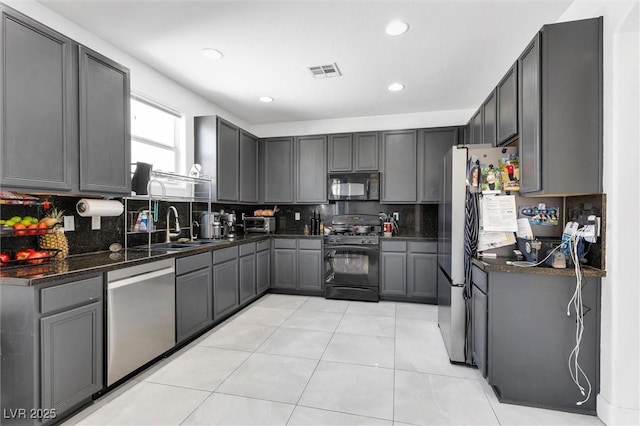 kitchen with black appliances, backsplash, recessed lighting, a sink, and gray cabinetry