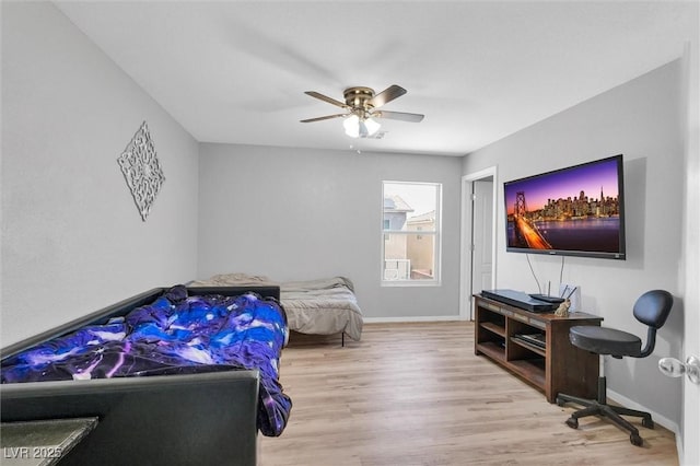 bedroom featuring wood finished floors, baseboards, and a ceiling fan