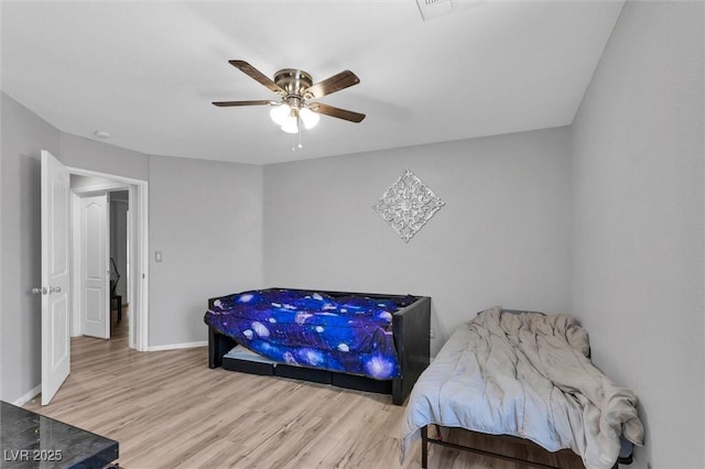 bedroom featuring wood finished floors, baseboards, and ceiling fan