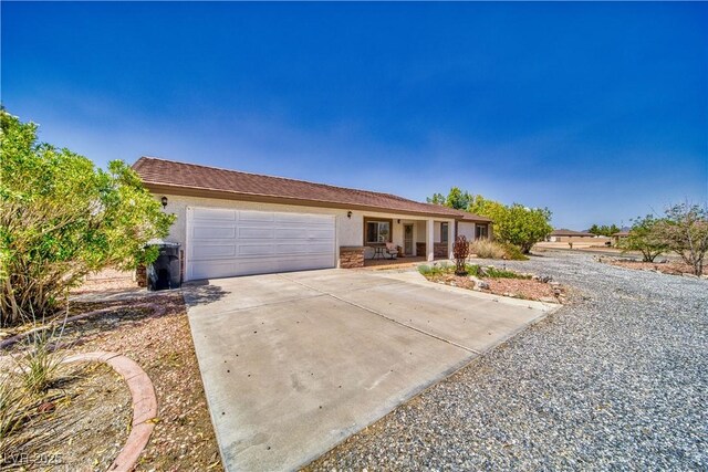 291 E Hickory St, Pahrump, NV 89048 - single story home with an attached garage, stucco siding, concrete driveway, and stone siding