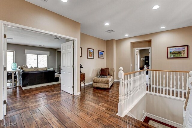 hallway with an upstairs landing, hardwood / wood-style flooring, baseboards, and recessed lighting