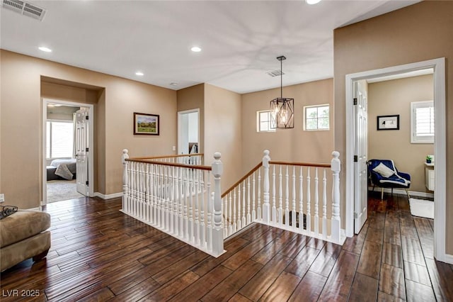hallway featuring an upstairs landing, wood finished floors, baseboards, plenty of natural light, and recessed lighting
