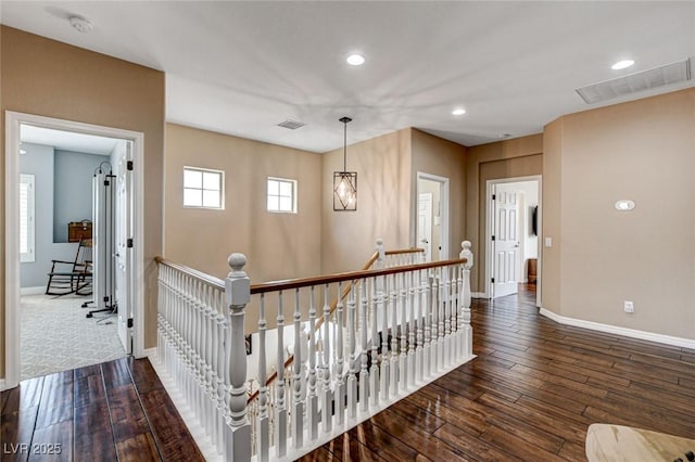 corridor with an upstairs landing, baseboards, dark wood-style flooring, and recessed lighting