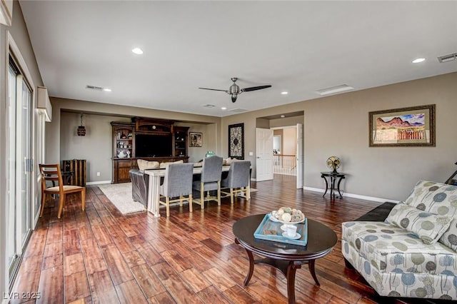 living area featuring wood finished floors, baseboards, ceiling fan, and recessed lighting