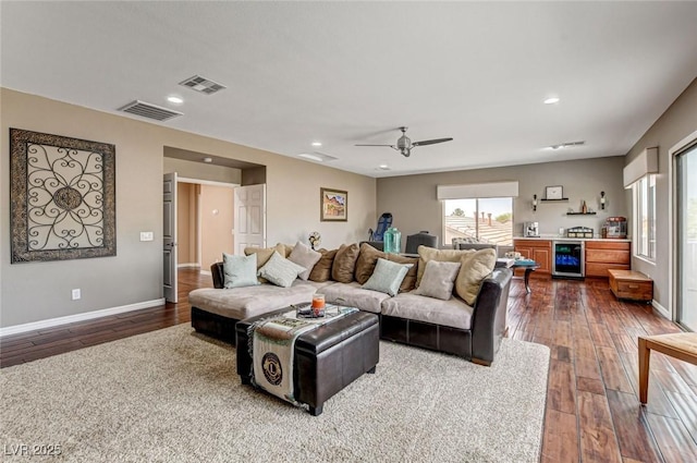 living room with dark wood-type flooring, beverage cooler, ceiling fan, recessed lighting, and baseboards