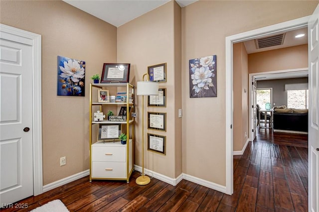 corridor with dark wood-type flooring and baseboards