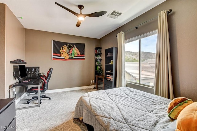 carpeted bedroom with baseboards, an office area, and ceiling fan
