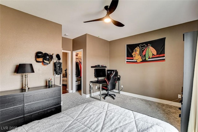bedroom featuring carpet floors, baseboards, a spacious closet, and a desk
