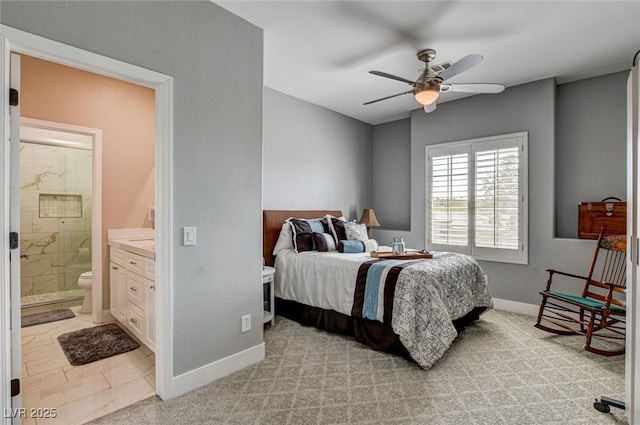 bedroom featuring baseboards, ensuite bathroom, and ceiling fan