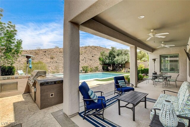view of patio with a fenced backyard, area for grilling, and ceiling fan