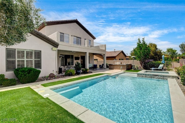 back of property with a balcony, a fenced backyard, exterior kitchen, a patio area, and stucco siding