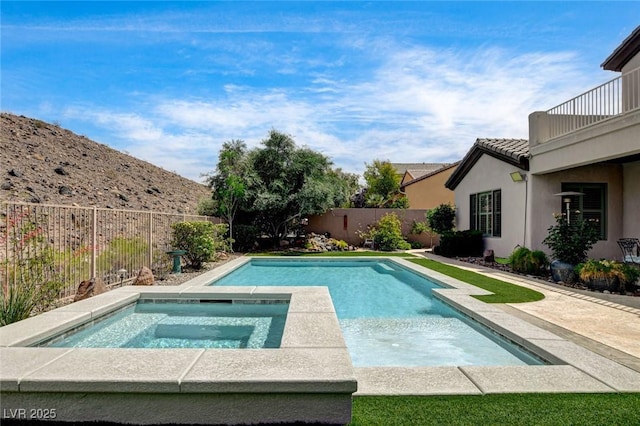 view of pool with an in-ground hot tub and a fenced backyard