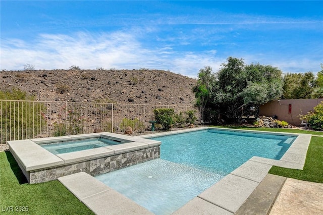 view of swimming pool with an in-ground hot tub and a fenced backyard