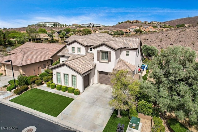 mediterranean / spanish house with stucco siding, a tiled roof, driveway, an attached garage, and a residential view
