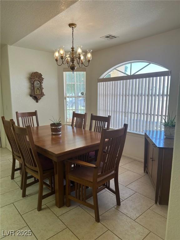 1461 E Elderberry St, Pahrump, NV 89048 - dining area featuring a chandelier, light tile patterned floors, and a textured ceiling