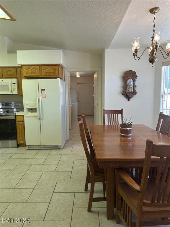 1461 E Elderberry St, Pahrump, NV 89048 - dining space with a chandelier, a textured ceiling, washer / clothes dryer, and vaulted ceiling