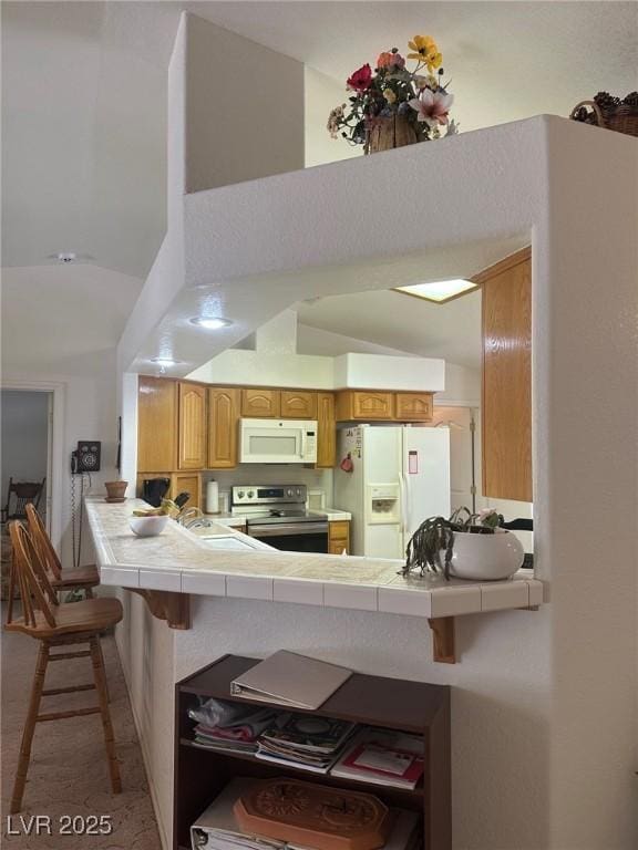 1461 E Elderberry St, Pahrump, NV 89048 - kitchen with white appliances, tile countertops, a peninsula, and a towering ceiling