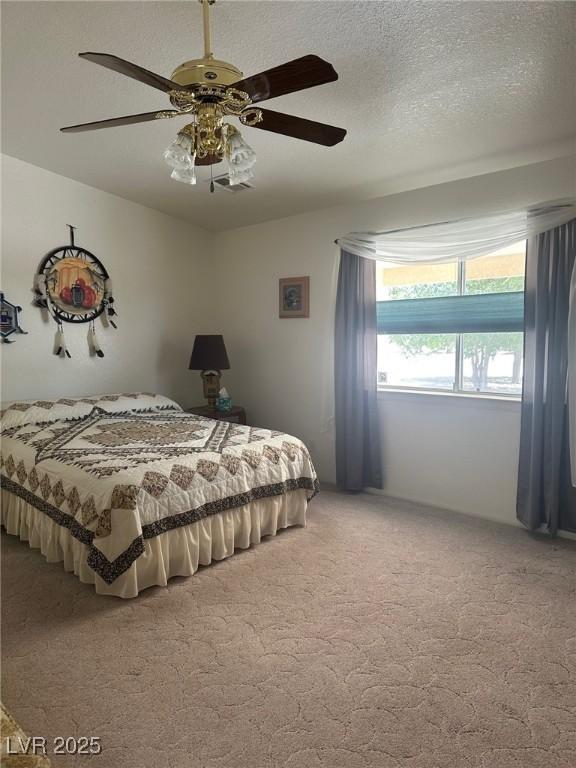 1461 E Elderberry St, Pahrump, NV 89048 - bedroom with light colored carpet, a ceiling fan, and a textured ceiling