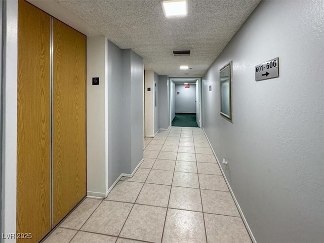 3930 University Center Dr Unit 603, Las Vegas, NV 89119 - hallway with a textured ceiling, light tile patterned floors, and baseboards