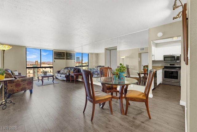 3930 University Center Dr Unit 603, Las Vegas, NV 89119 - dining area with wood finished floors and a wall of windows