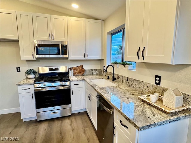 407 Tiger Lily Way, Henderson, NV 89015 - kitchen with appliances with stainless steel finishes, a sink, wood finished floors, white cabinets, and recessed lighting