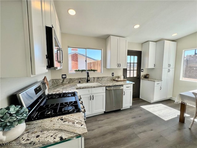 407 Tiger Lily Way, Henderson, NV 89015 - kitchen with appliances with stainless steel finishes, a sink, white cabinets, light stone counters, and dark wood finished floors
