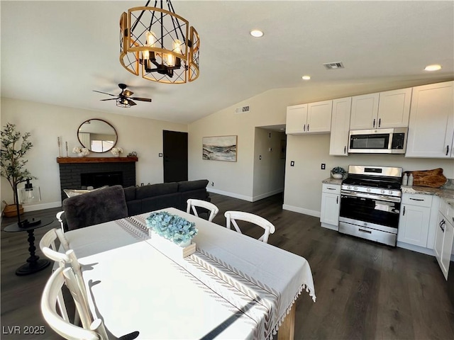 407 Tiger Lily Way, Henderson, NV 89015 - dining room with baseboards, lofted ceiling, a ceiling fan, dark wood-style flooring, and a brick fireplace