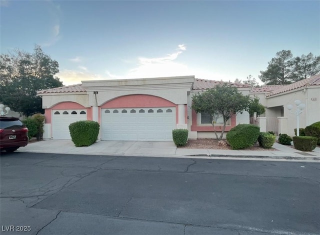 5165 Briar Meadow Way, Las Vegas, NV 89118 - view of front of house featuring an attached garage, a tiled roof, driveway, and stucco siding