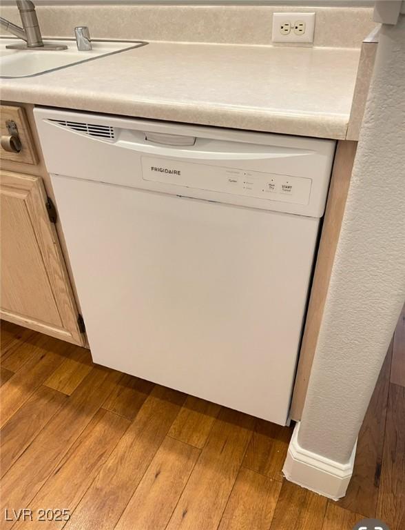 5165 Briar Meadow Way, Las Vegas, NV 89118 - detailed view of white dishwasher, a sink, wood finished floors, and light countertops