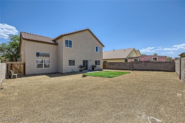 5502 Cinnamon Ave, Las Vegas, NV 89122 - rear view of property featuring a fenced backyard, stucco siding, and a tile roof
